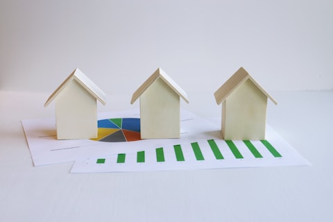 three small houses sitting on top of a piece of paper