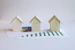 three small houses sitting on top of a piece of paper