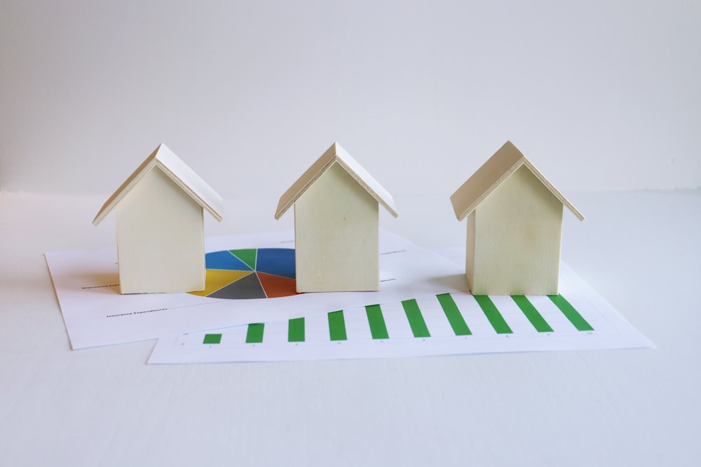 three small houses sitting on top of a piece of paper