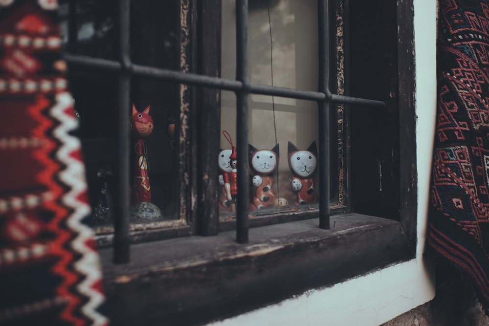 a window with a couple of cats on the window sill