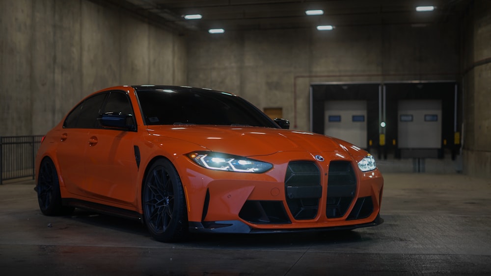 an orange sports car parked in a parking garage