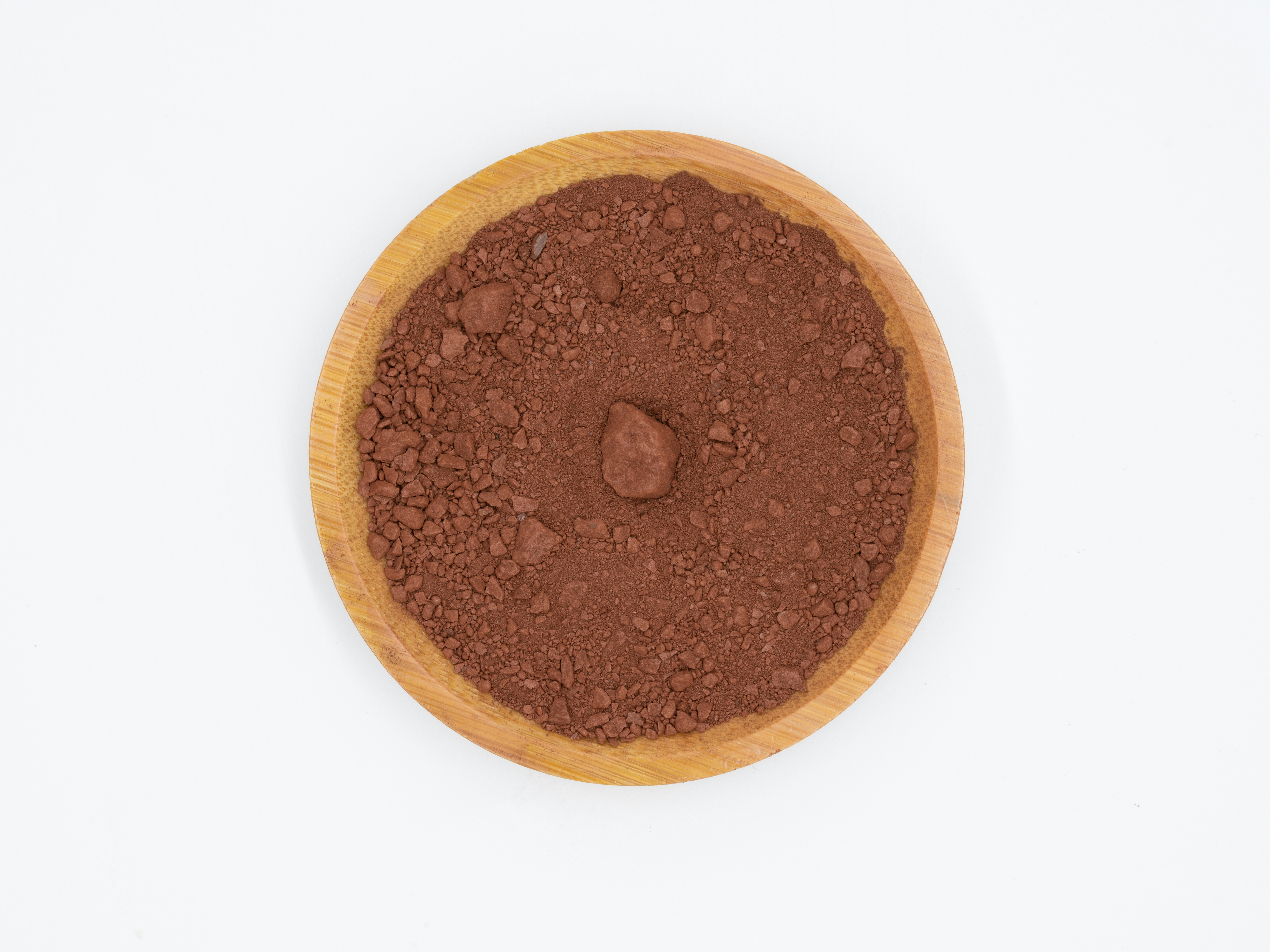 Dark cocoa powder pile with wooden spoon, rich brown color, airy light background