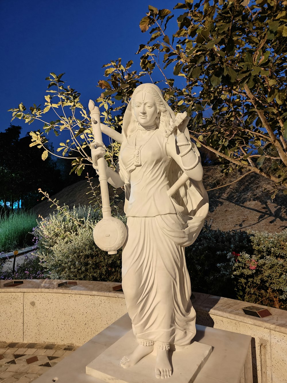 a statue of a woman holding a potted plant