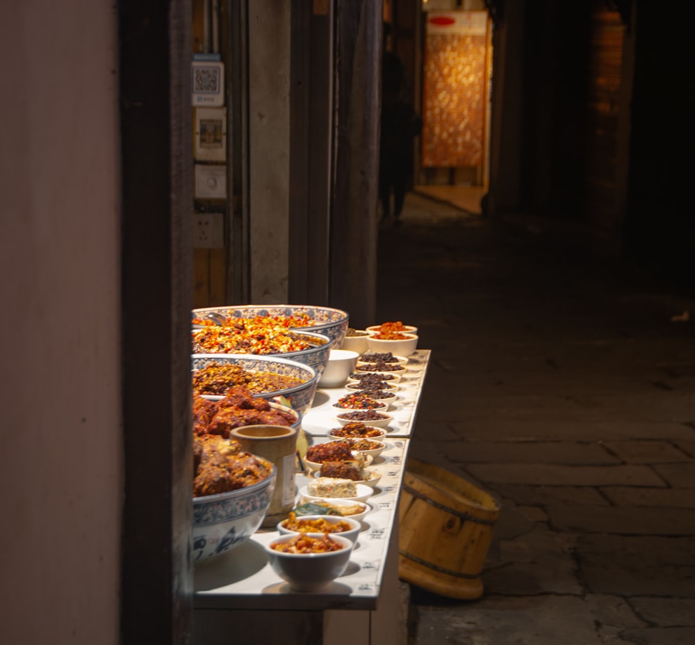 a long table with many bowls of food on it