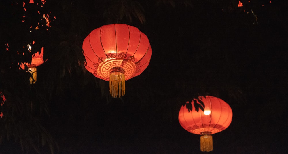a group of red lanterns hanging from a tree