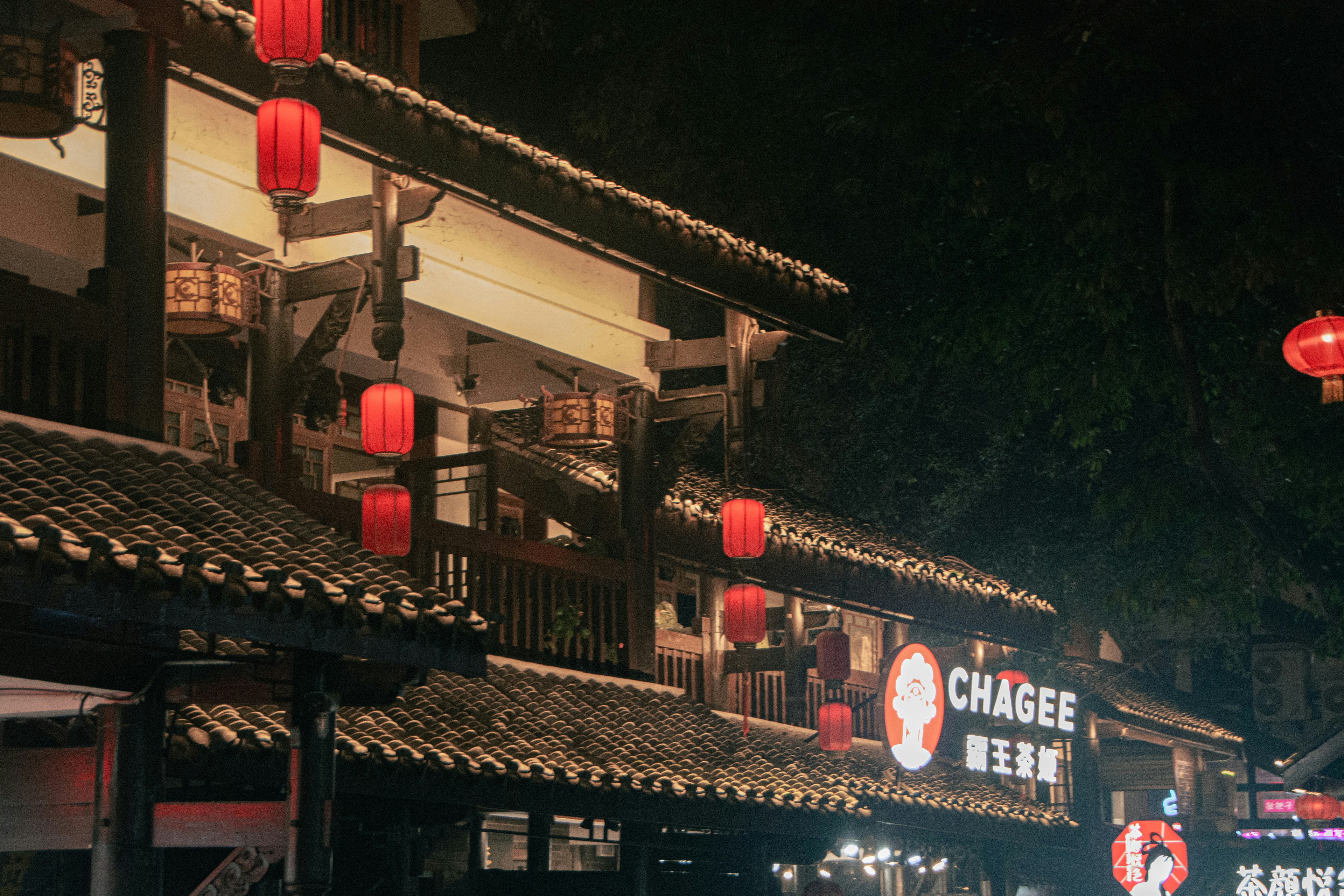 a building with red lanterns hanging from it's roof