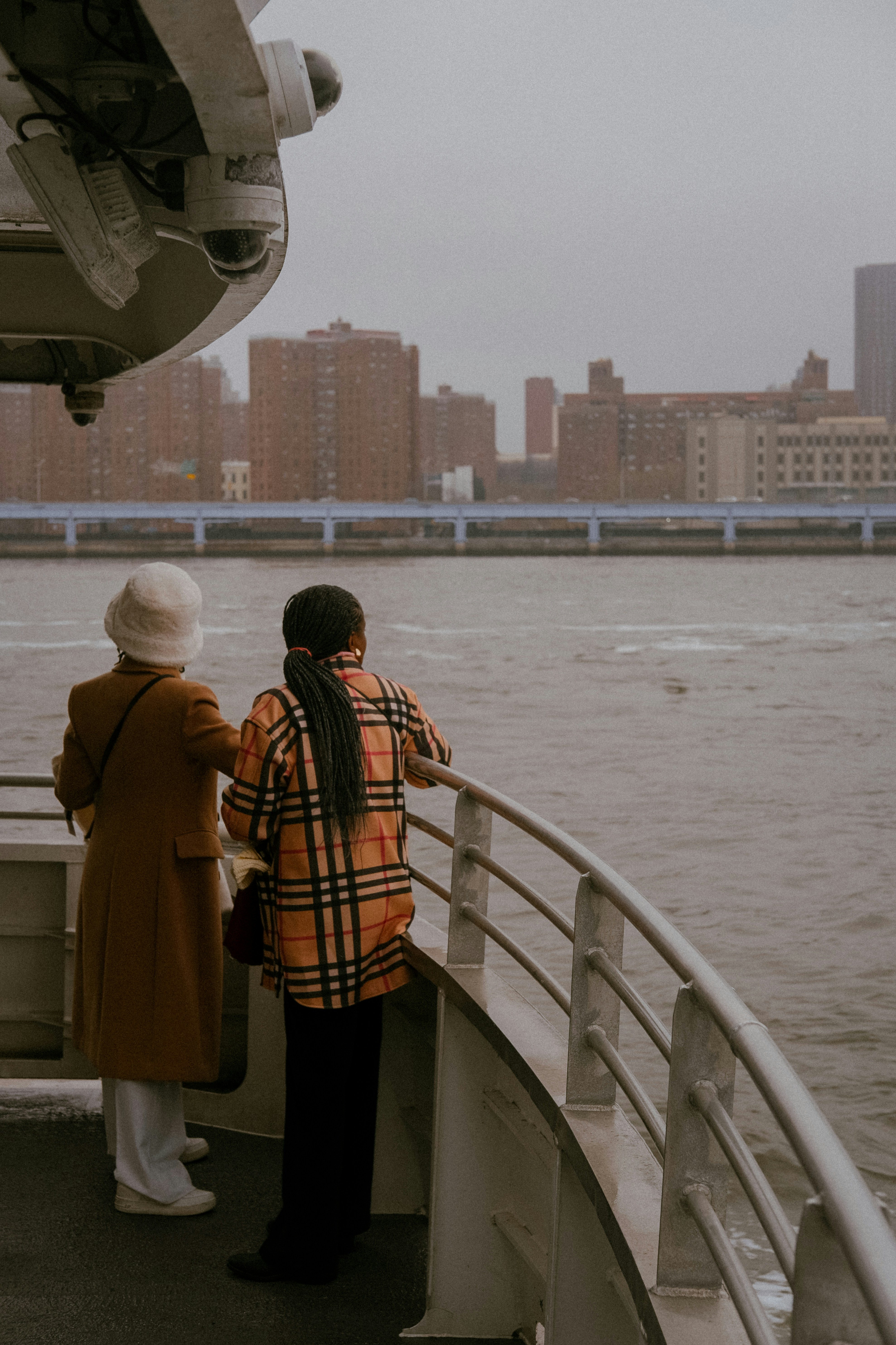 two people standing on a boat looking out at the water
