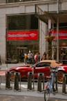 a red sports car is parked in front of a bank of america
