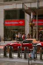 a red sports car is parked in front of a bank of america