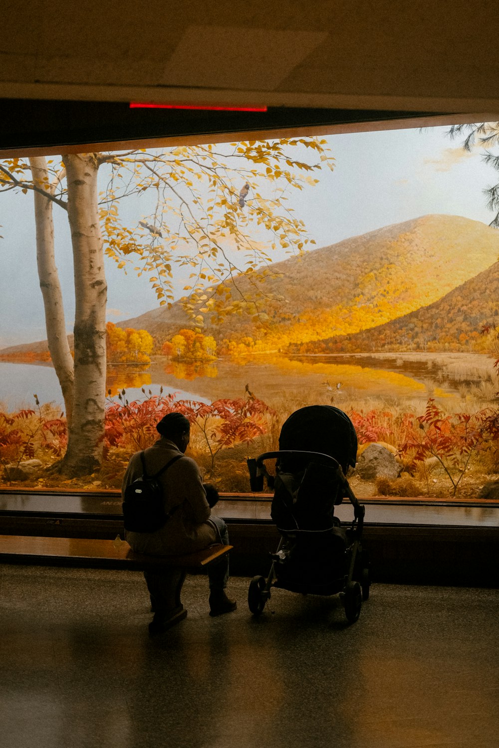 a couple of people sitting next to each other in front of a painting