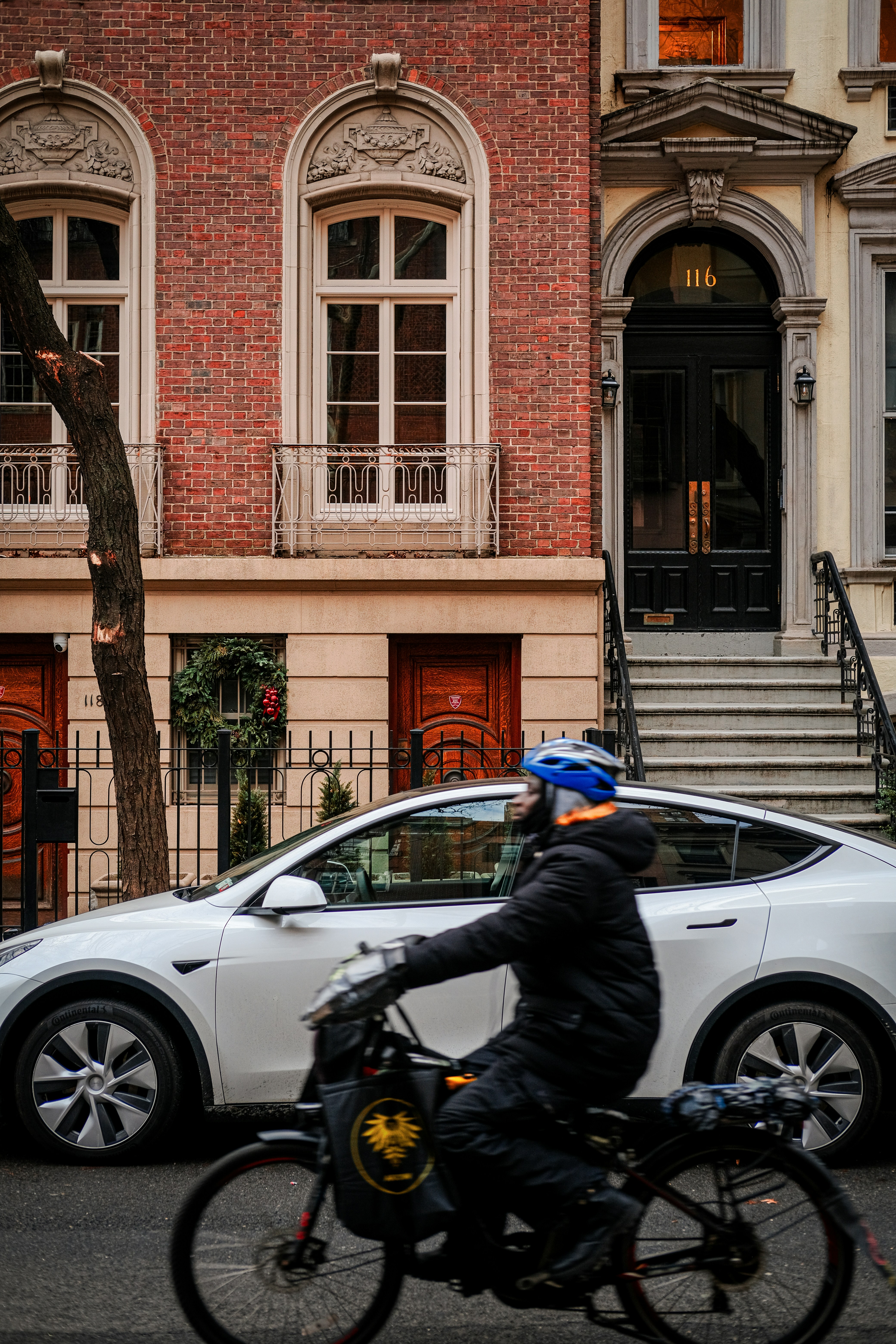 a man riding a bike next to a white car