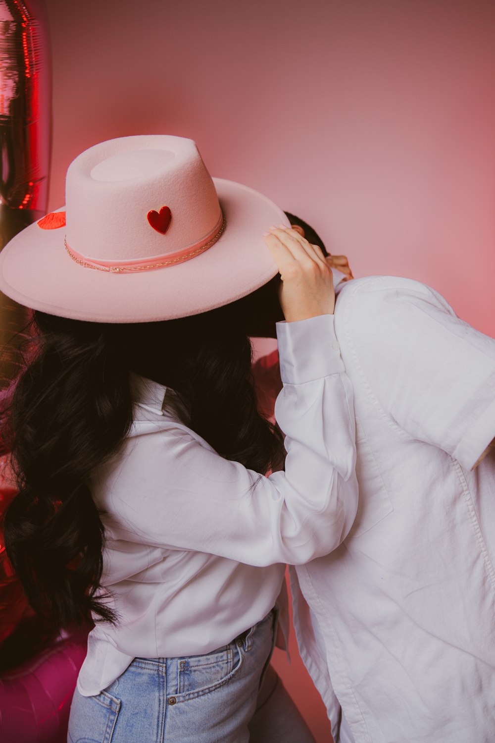 a woman in a white shirt and a pink hat