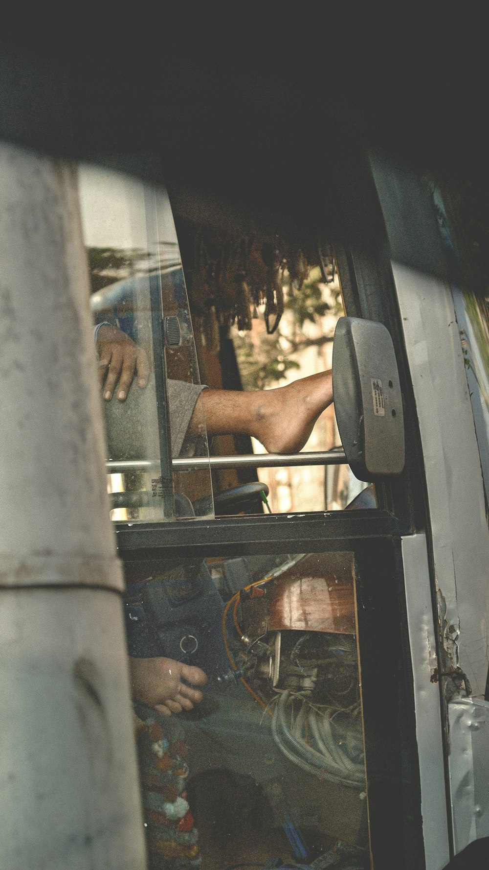 a man sitting inside of a bus looking out the window