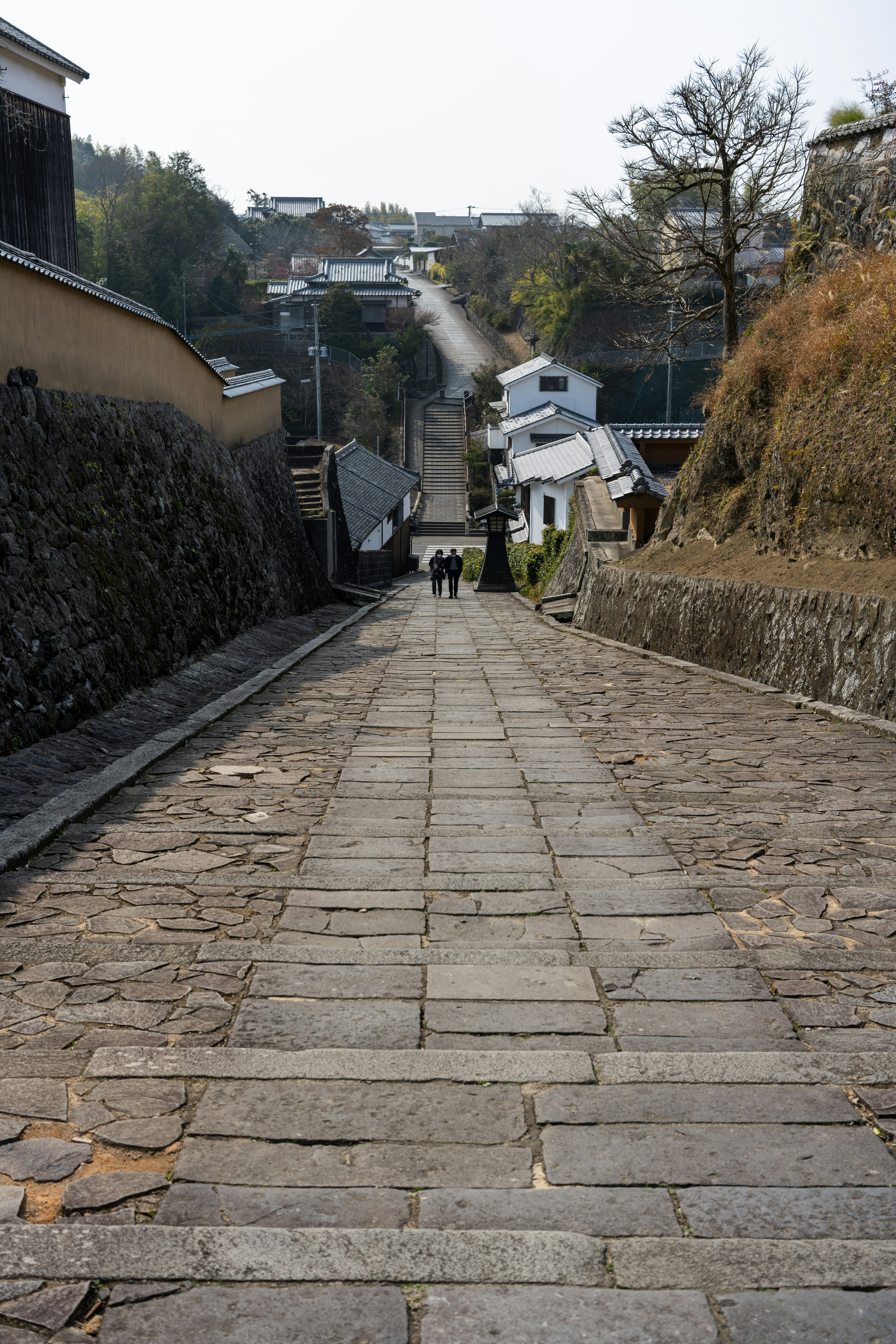 uma rua de paralelepípedos com uma pessoa caminhando por ela