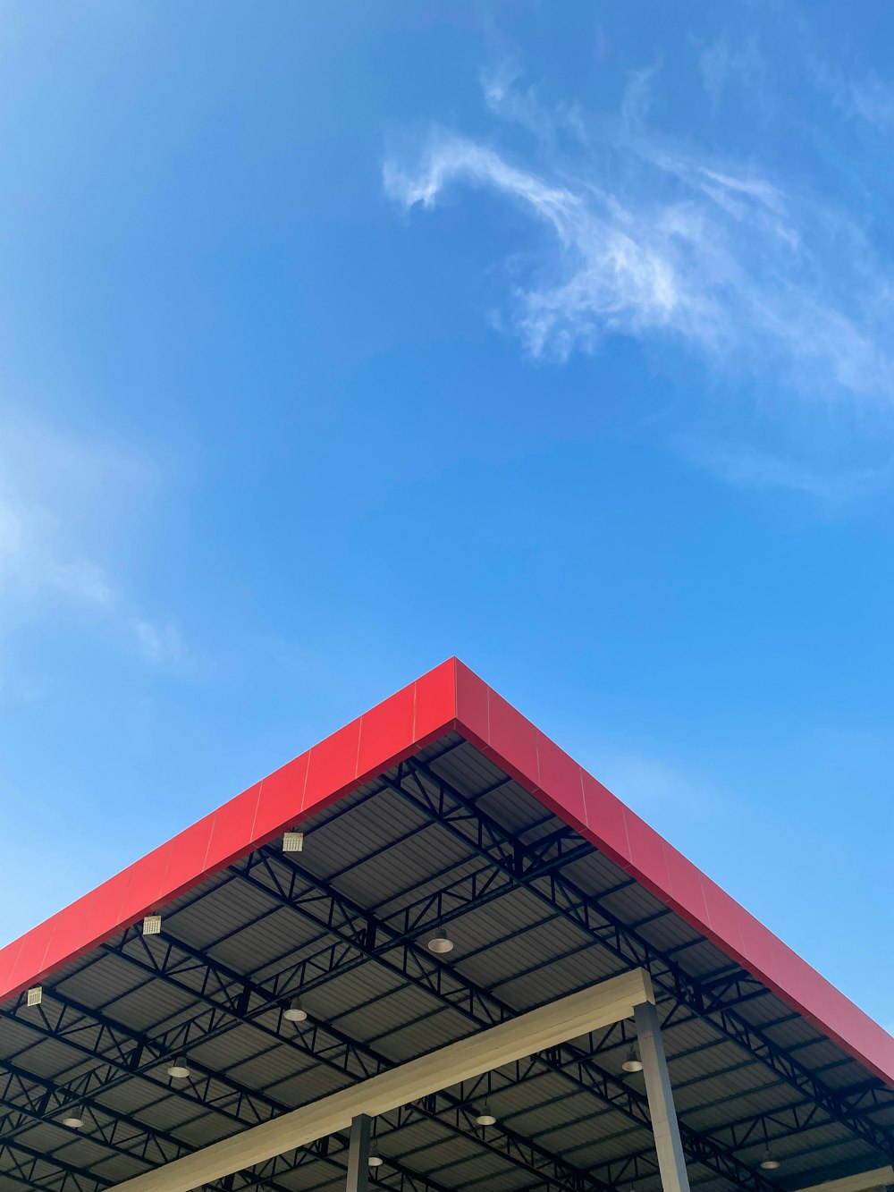 an airplane is flying over a building under a blue sky