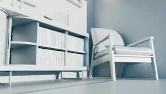 a white chair sitting next to a book shelf