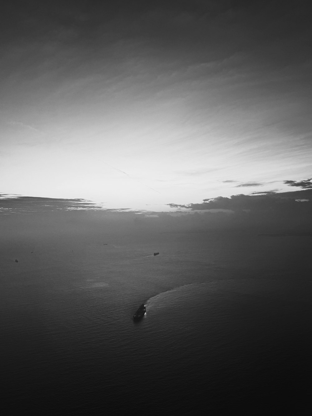 a black and white photo of a boat in the ocean