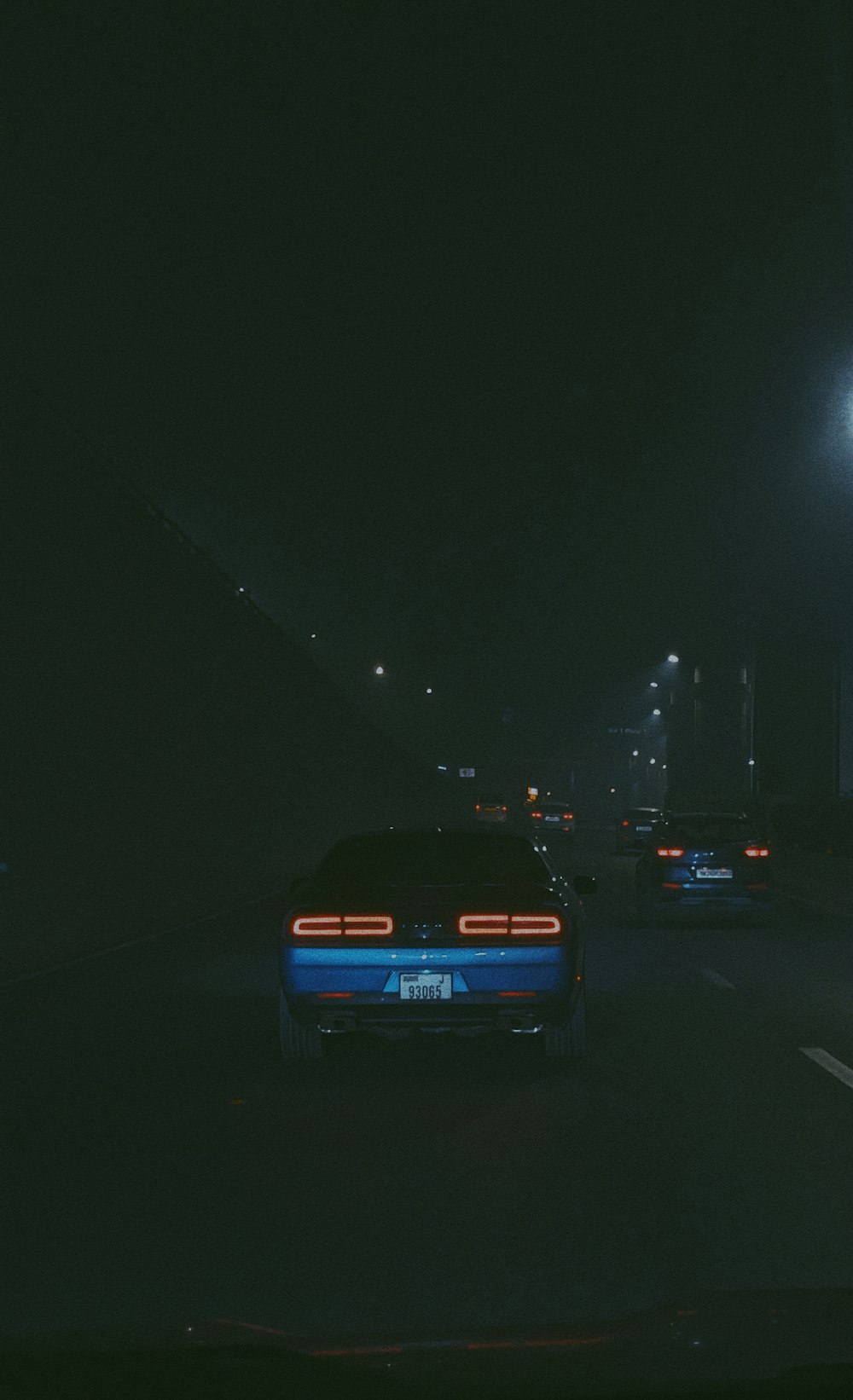 a car driving down a street at night