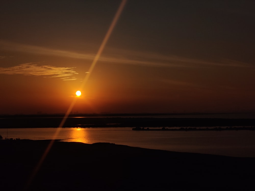 the sun is setting over a body of water