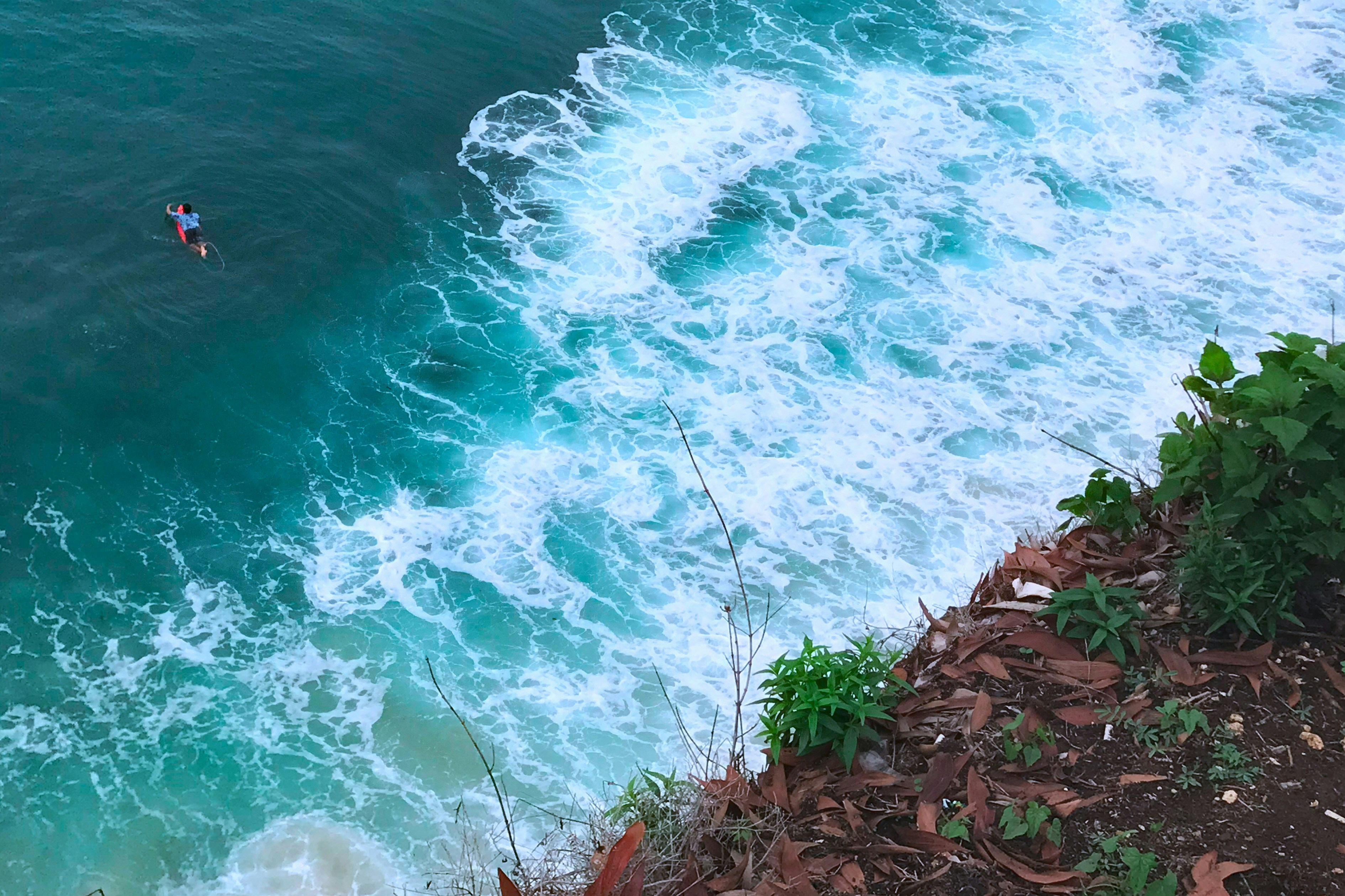 a man riding a surfboard on top of a wave in the ocean