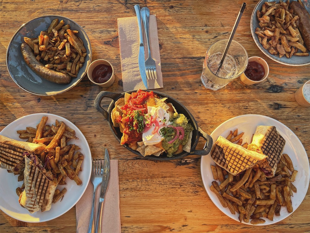 a wooden table topped with plates of food