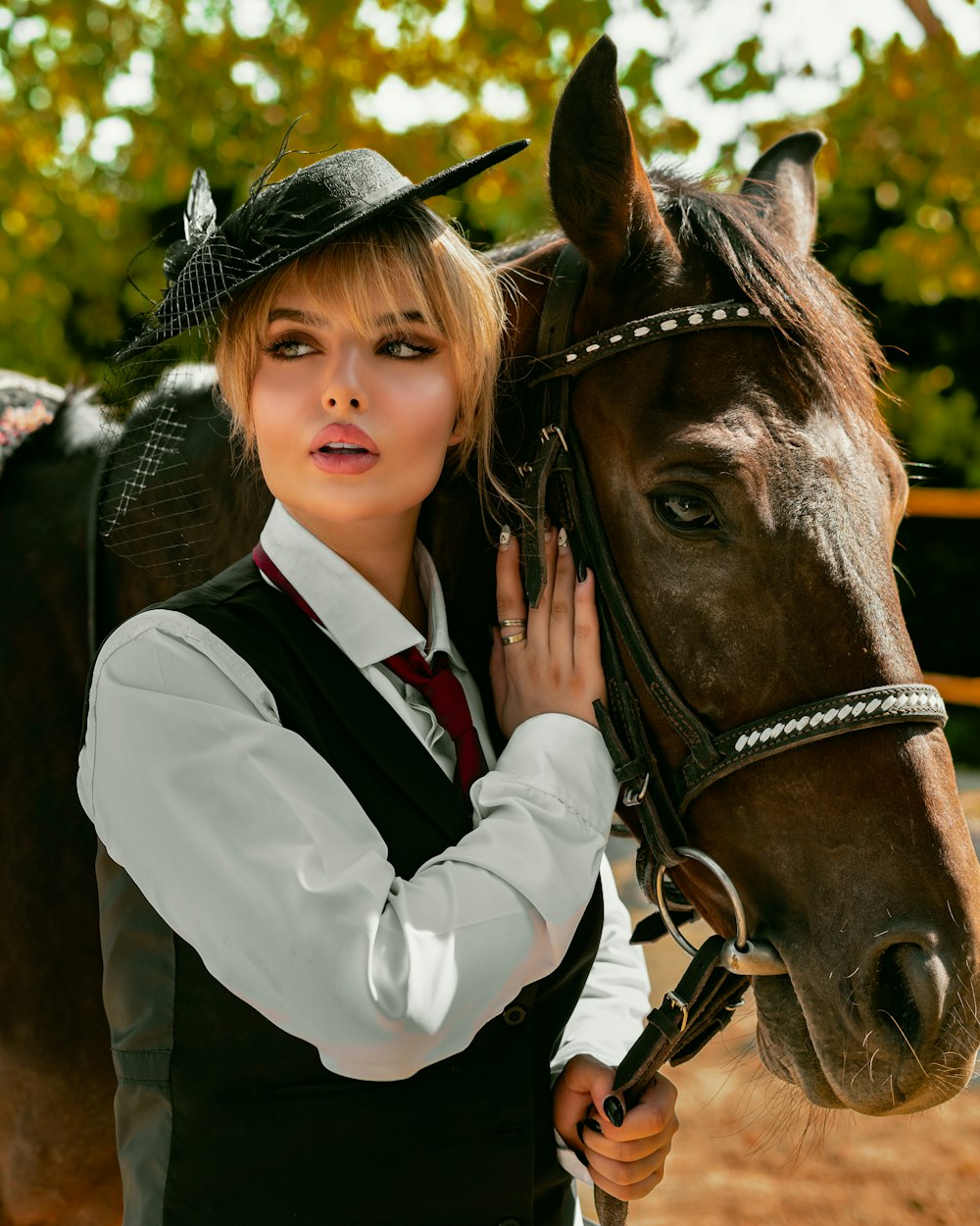 a woman in a cowboy hat standing next to a horse