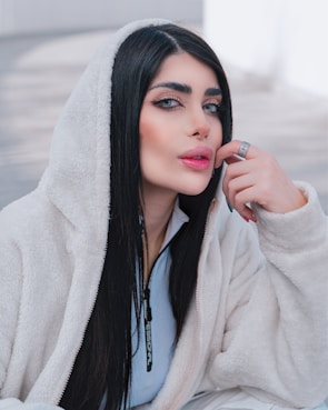 a woman with long black hair wearing a hoodie