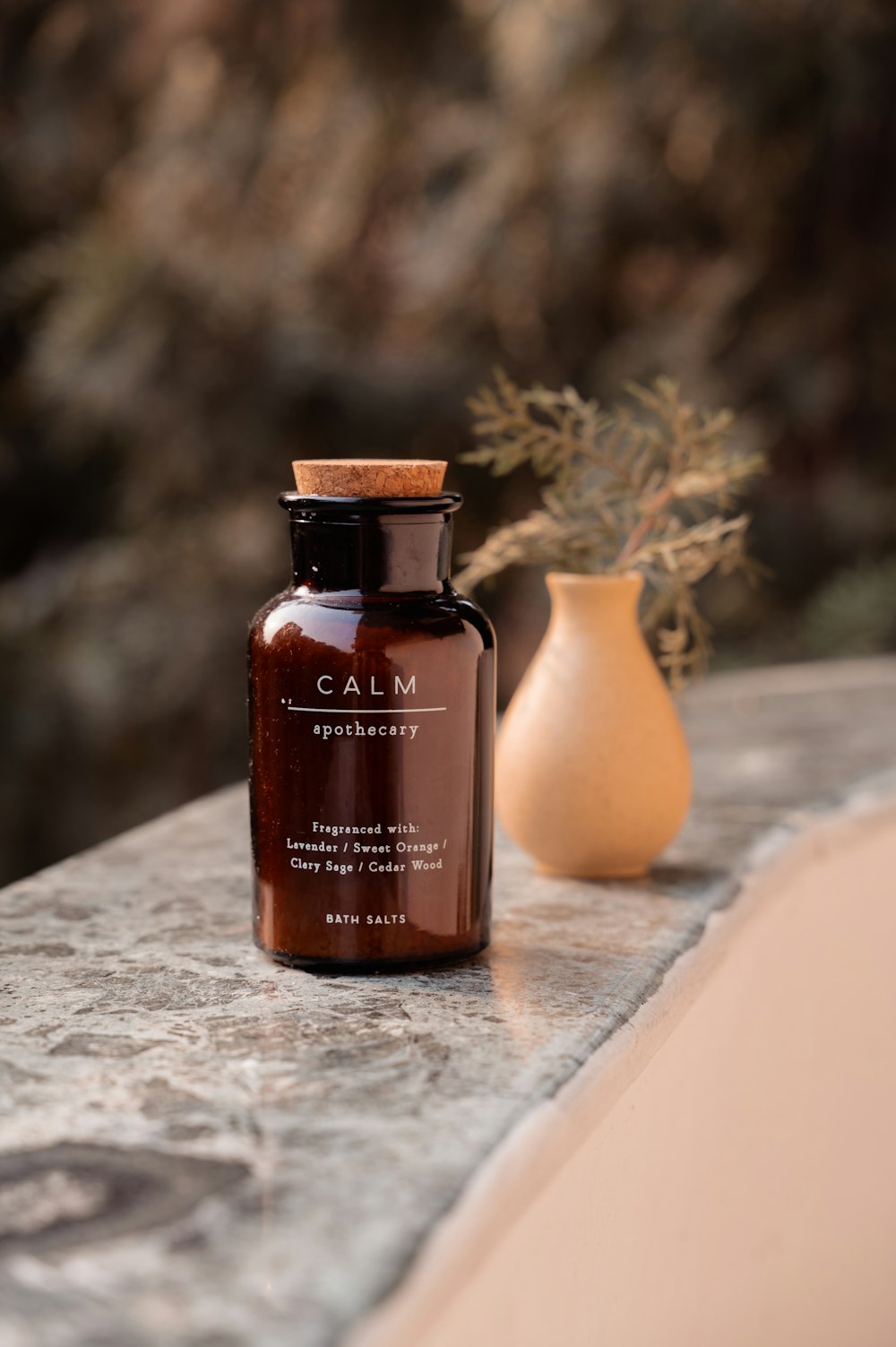 a bottle of calm on a ledge next to a vase