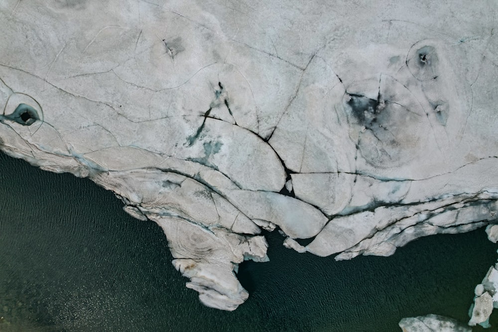 an aerial view of a glacier with water and rocks