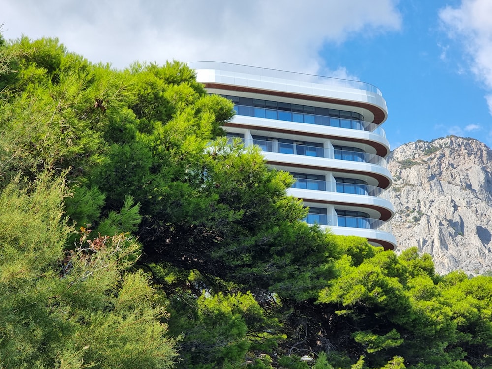 a very tall building surrounded by trees and mountains