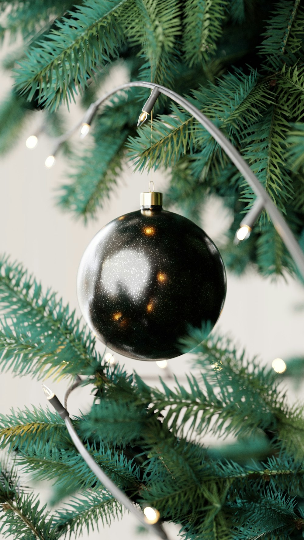 a black ornament hanging from a christmas tree
