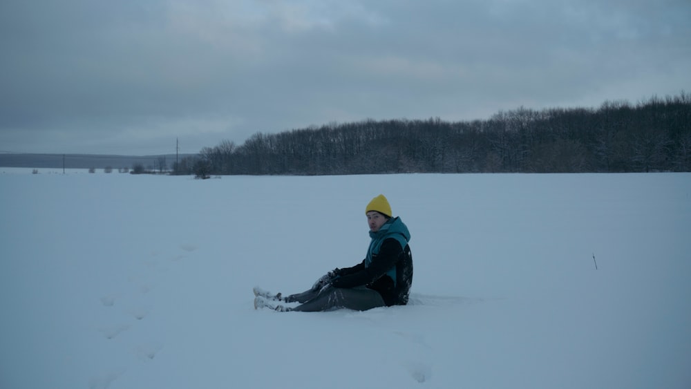 a person sitting in the snow on a cloudy day