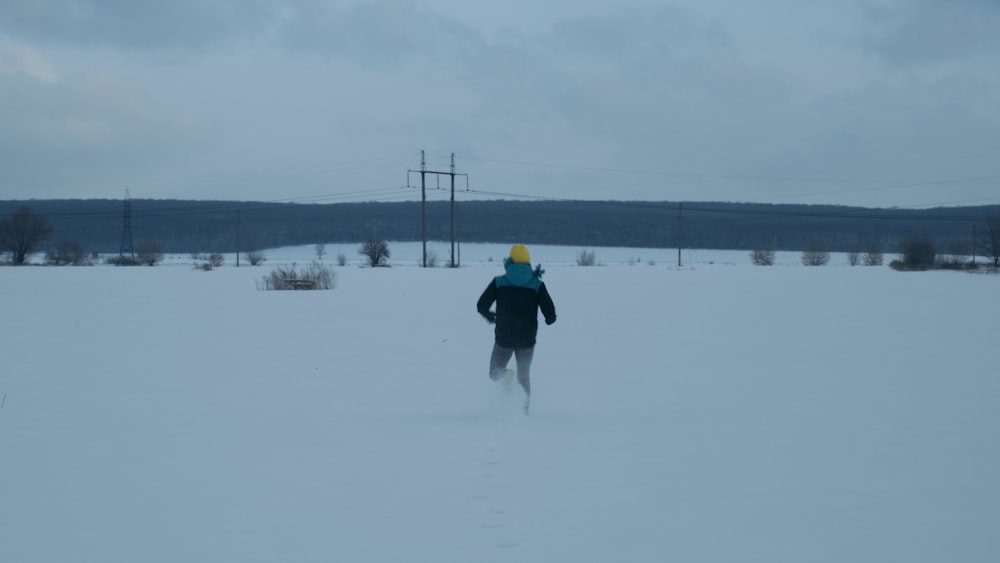 a person walking across a snow covered field