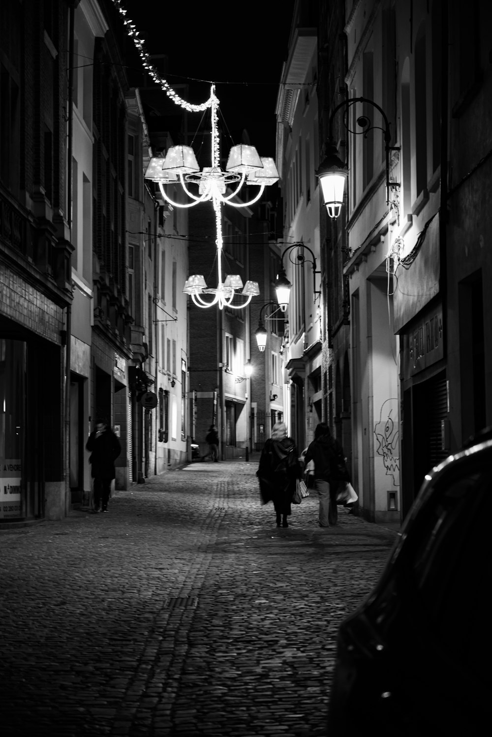 a black and white photo of a street at night