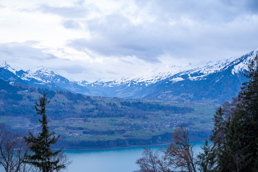 a scenic view of a mountain range with a lake in the foreground