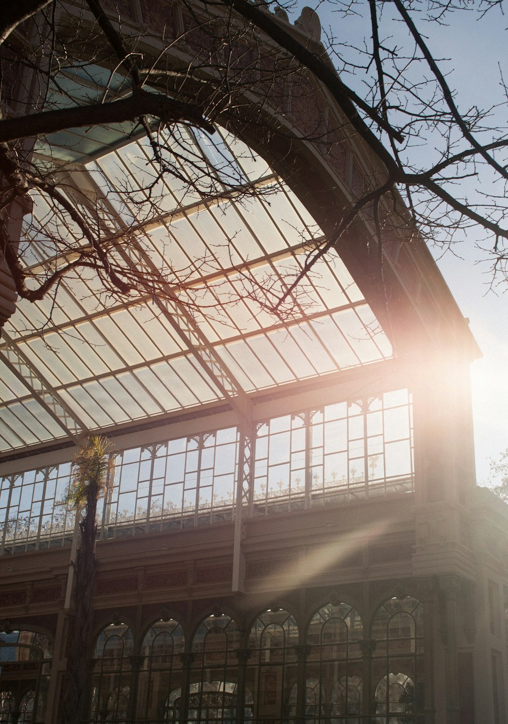 the sun shines through the glass roof of a building