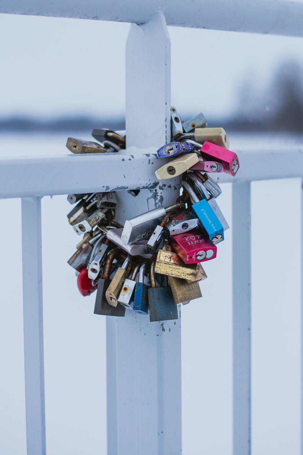 a bunch of locks attached to a white fence