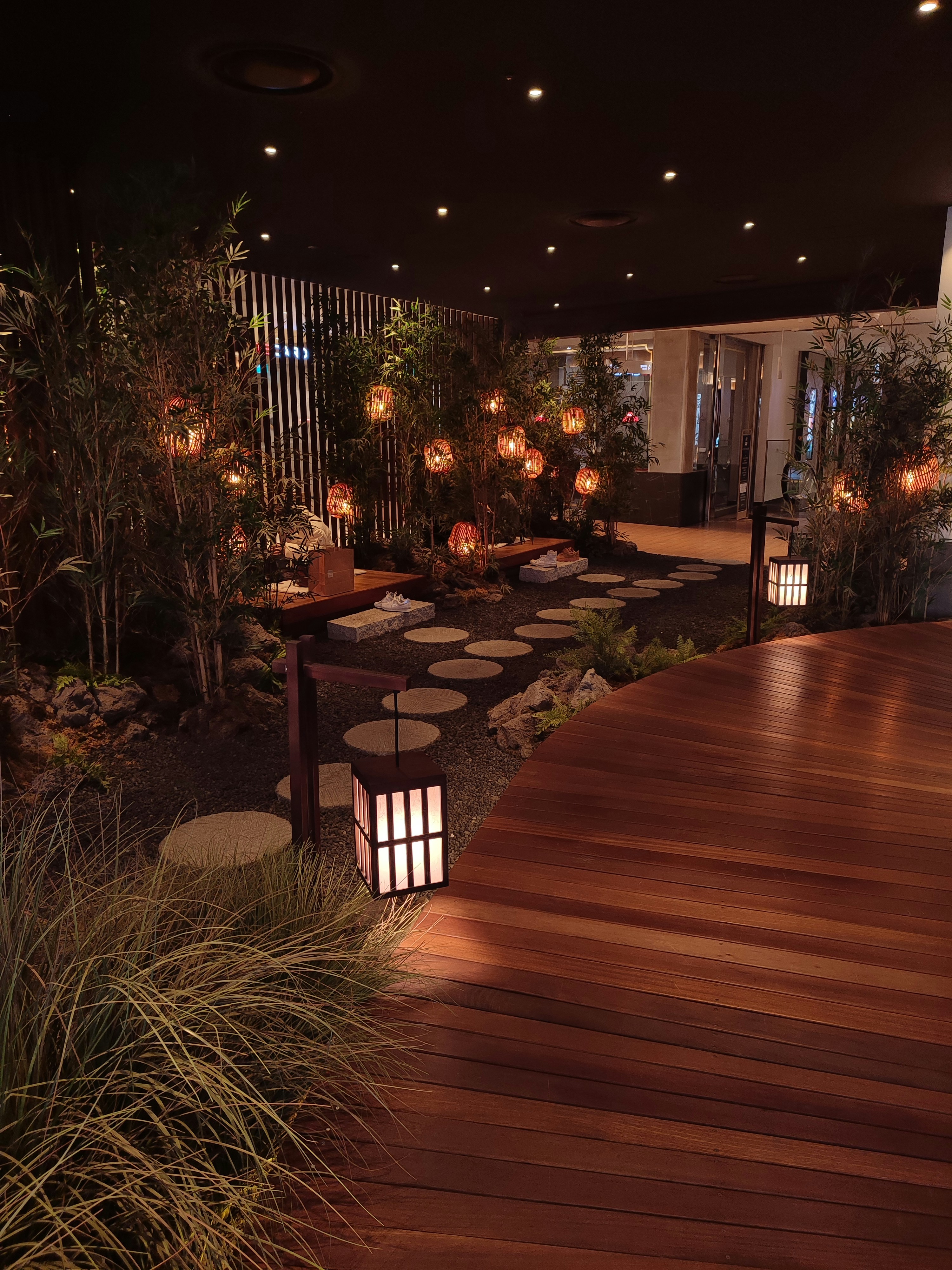 a wooden walkway with lanterns lit up at night
