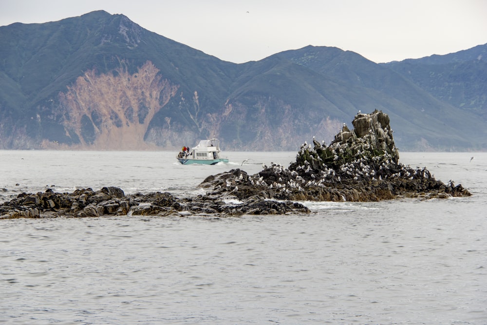 Un barco en un cuerpo de agua con montañas al fondo