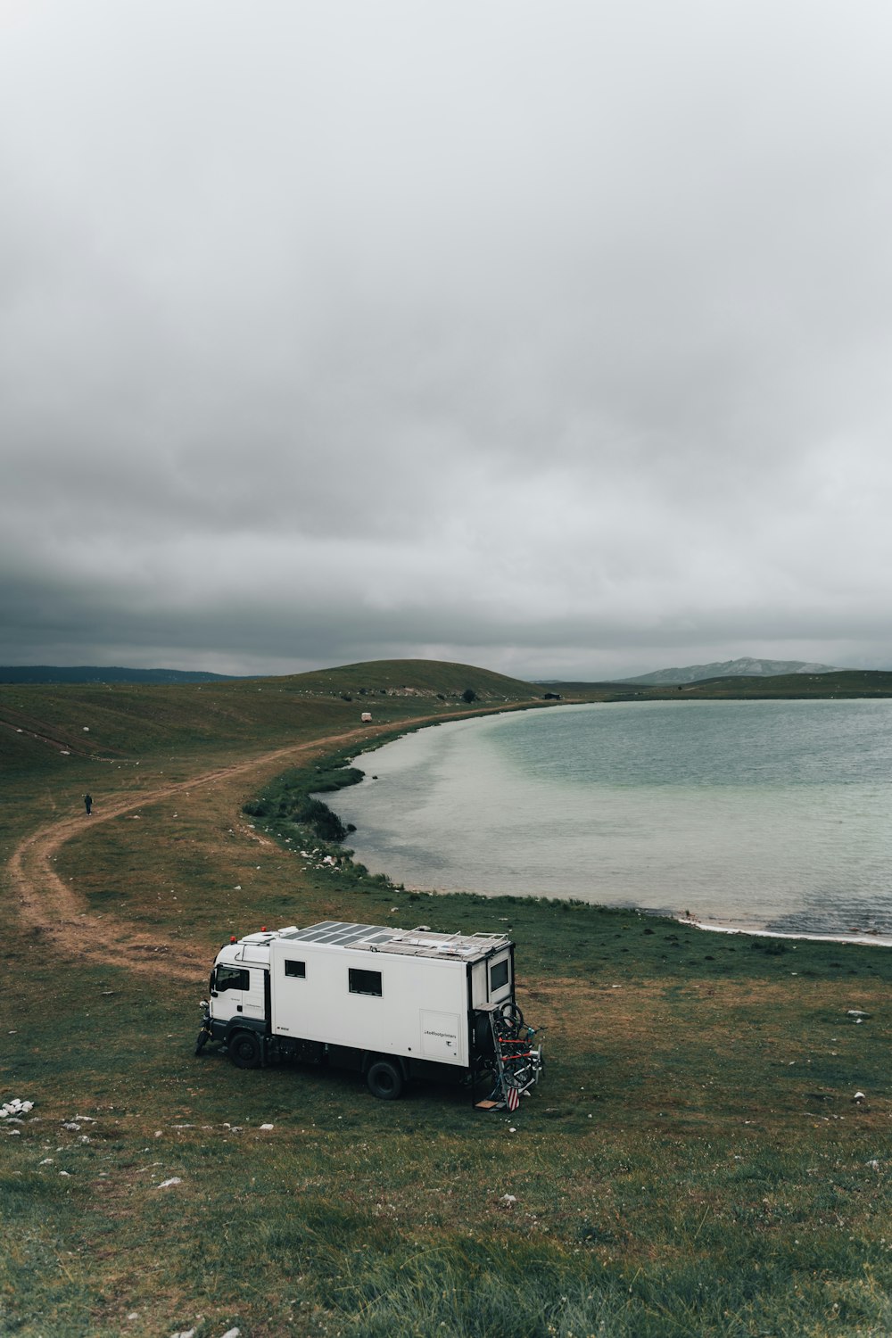 a white trailer parked on top of a grass covered field