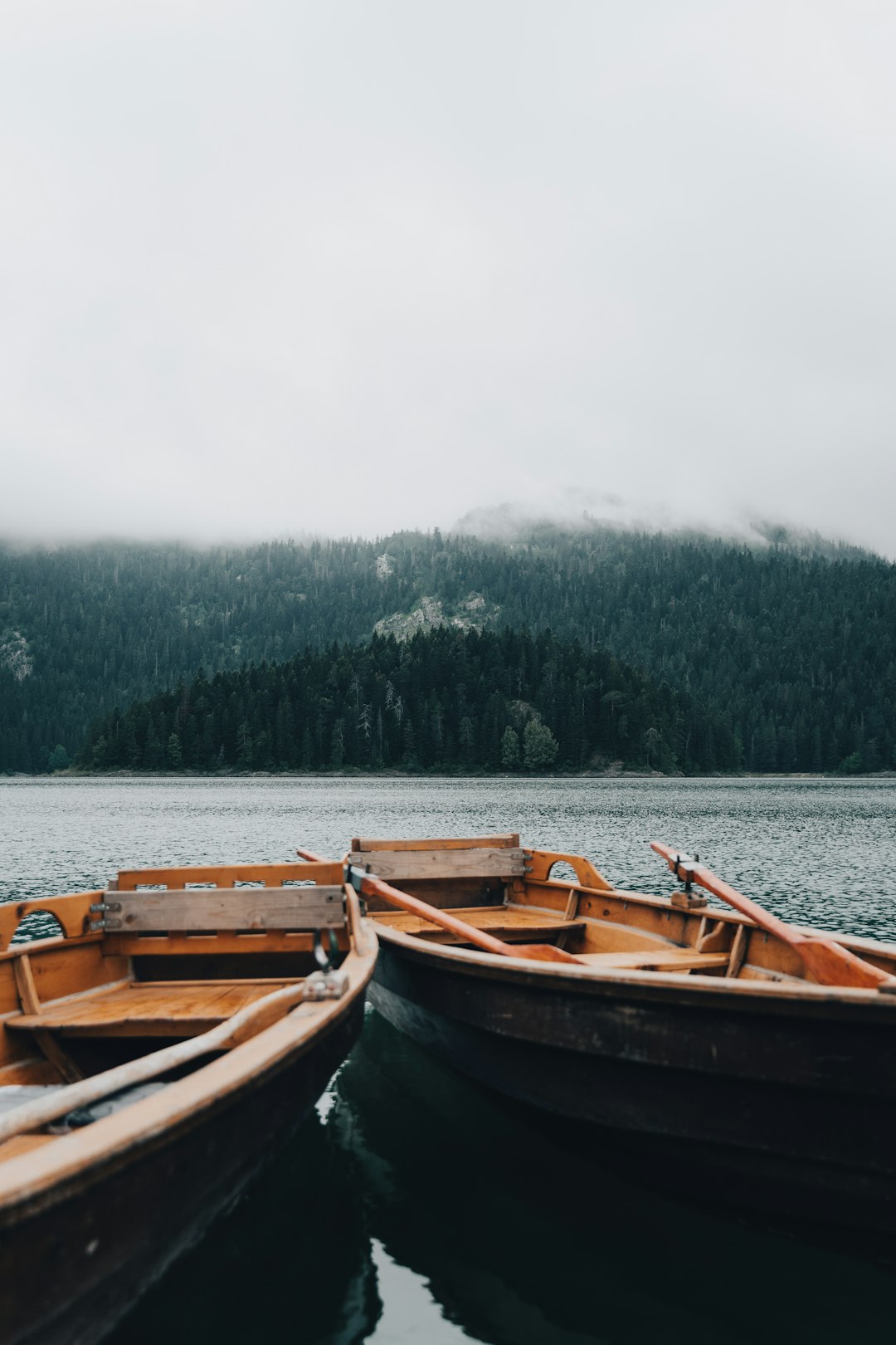 two small wooden boats sitting on top of a lake