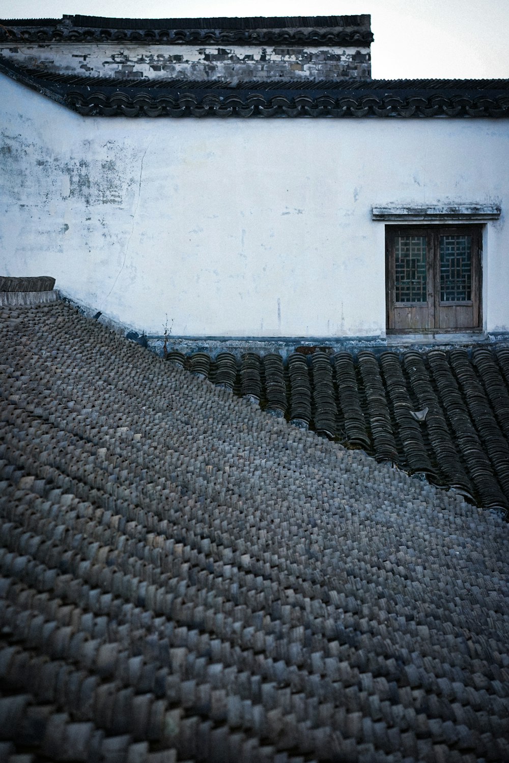 a black and white photo of a roof and a window