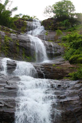 a large waterfall with water cascading down it's sides
