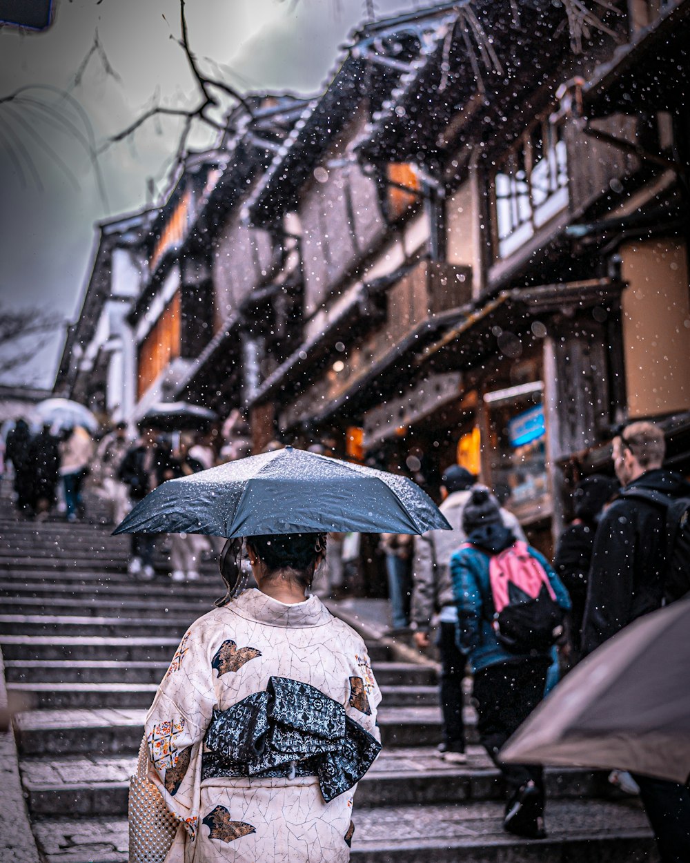 a woman with an umbrella is walking down the stairs