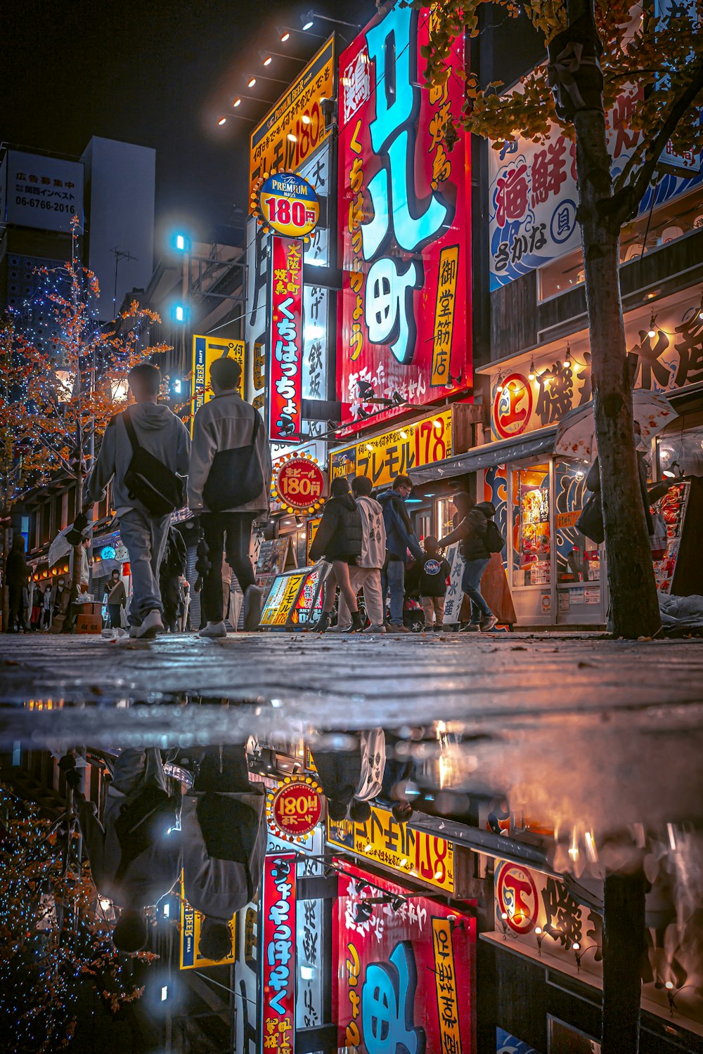 a group of people walking down a street at night