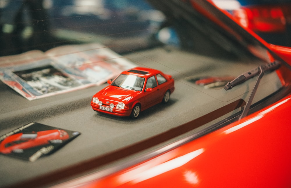 a red toy car sitting on top of a table