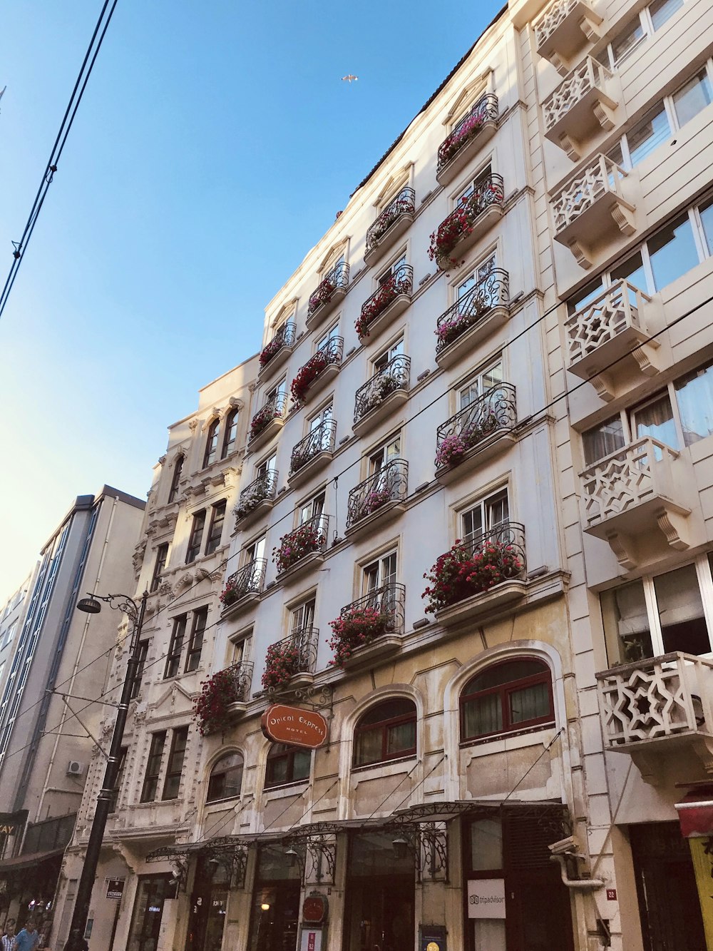 a tall building with balconies and flowers on the balconies