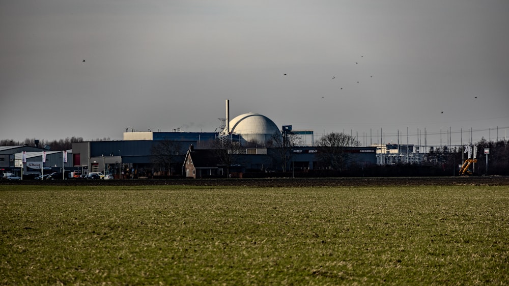 a large factory building sitting on top of a lush green field