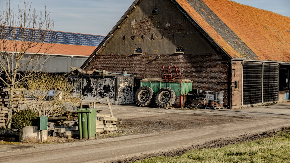 an old barn with a tractor parked in front of it