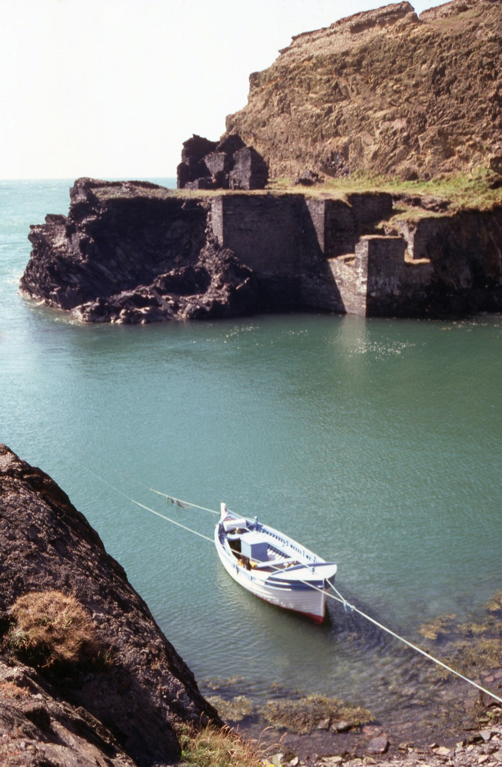 a small boat tied up to a rocky shore